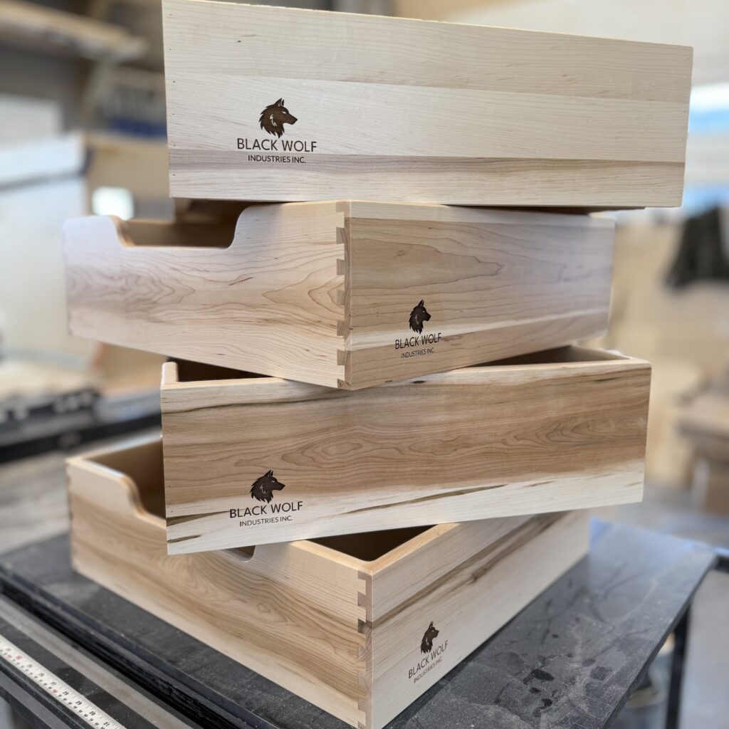 Maple drawer boxes stacked up, showing dovetail joinery.