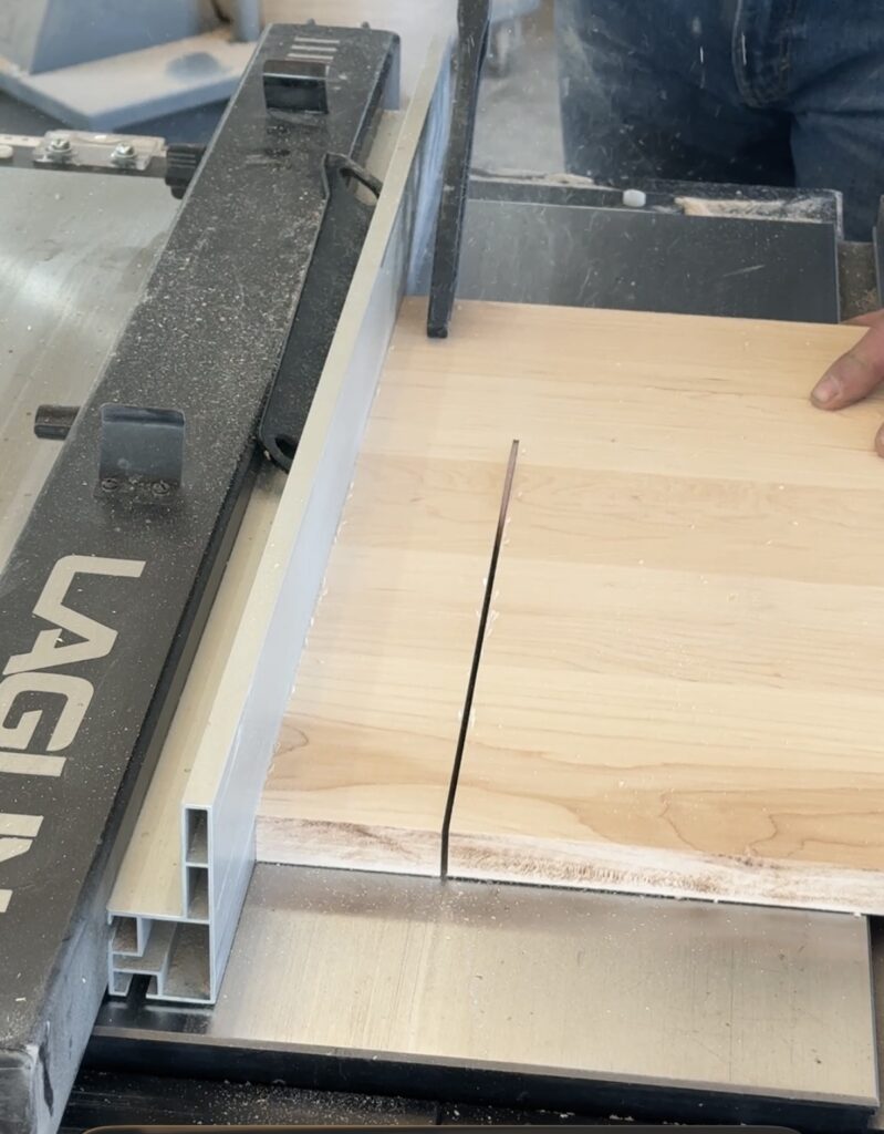 Image of table saw in action, cross cutting a board.
