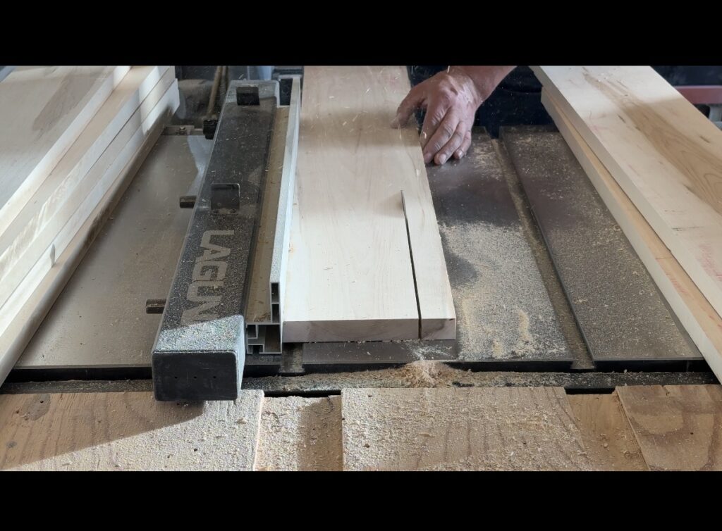 Image of table saw in action rip cutting a board to width